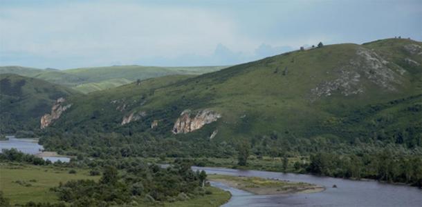 Neanderthal hunting grounds in southern Siberia — the Charysh River valley, with Chagyrskaya Cave in the center of the photo. (Image: Institute of Archaeology and Ethnography of the Siberian Branch of the Russian Academy of Sciences, Author provided)