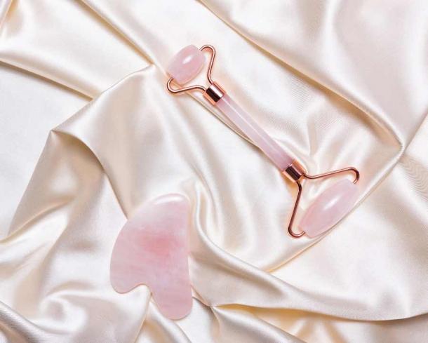 Pink jade face massage roller and Gua Sha pink quartz stone. (romanovad / Adobe Stock)