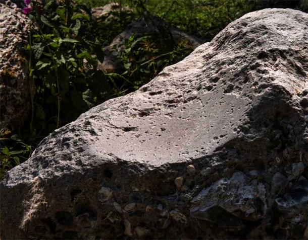 The polishing stone, or polissoir, has a distinctive glossy dip where stone axe heads were once polished 5,000 years ago. (Historic England)