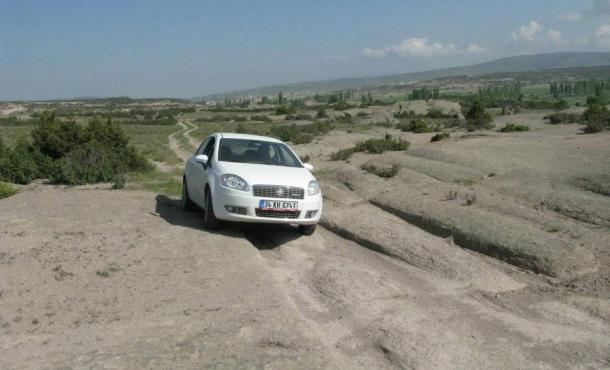 The prehistoric mysterious vehicle tracks as found in the Phrygian Valley of Turkey, with a modern car for scale.