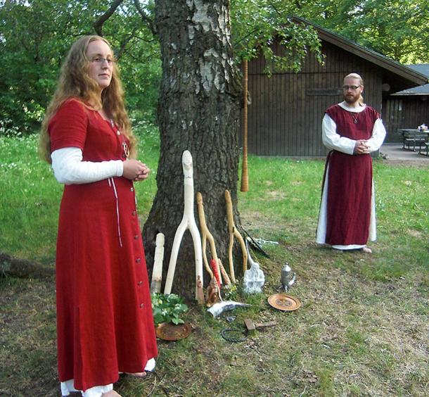 In Sweden, a priestess and a priest perform a ceremony during an annual Asatru thing (meeting). Under the tree are images of Norse gods Thor, Frigg, Freyr, Freya and Forseit with a ceremonial hammer, a drinking horn and an oath ring. Hanging on the birch tree, which is sacred to the goddess Frigg, hangs a birch trumpet.