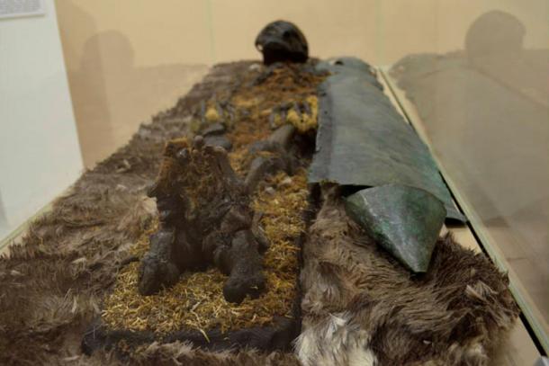 'A red-haired man was found, protected from chest to foot by copper plating. In his resting place, was an iron hatchet, furs, and a head buckle made of bronze depicting a bear.' 