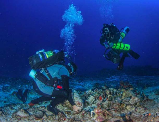 Research scientist Dr. George Koutsouflakis moves an amphora from the Antikythera shipwreck cargo. (Greek Ministry of Culture)