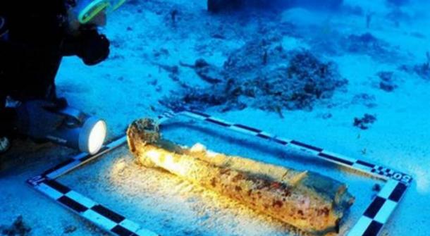 Examining the sculpture’s legs underwater.