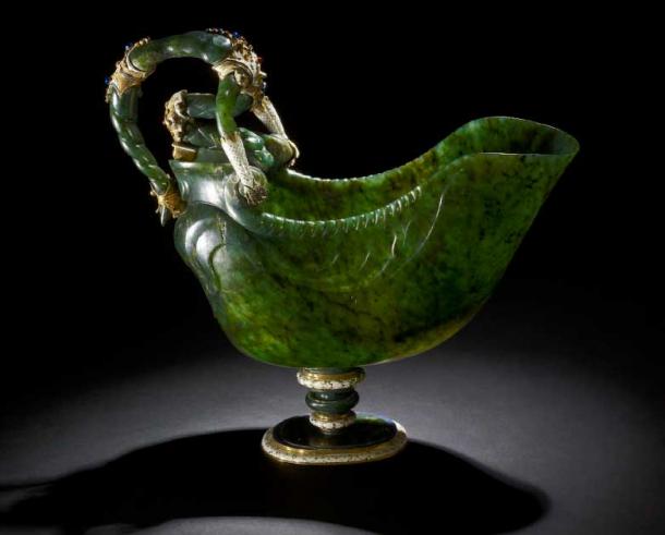 Shell-shaped cup made in Milan c. 1600 AD. Dark green jade; mounted in gold and enamelled; sides with honeysuckle pattern in low relief; handles formed of contorted dragon-like figure with two arms gripping the sides; mounts chased and enamelled white, details in ruby and sapphire colours (CC by SA 4.0 / Trustees of the British Museum)
