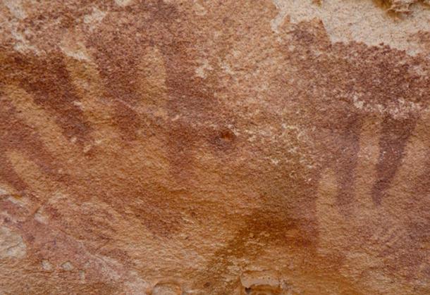 Image of tiny “handsprints”, which may have been made by reptiles, inside adult human handprints at the Wadi Sura II rock shelter.
