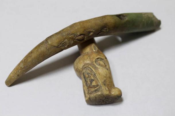 The cheek piece is decorated with carving - on one end, the head of a snow leopard or wolf, and on the other a griffin.