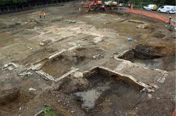 The stone footprint of the farmhouse, with a contemporary bridge visible in the foreground. (Cotswold Archaeology)