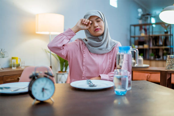 A tired Muslim woman awakening early during Ramadan. (Odua Images/Adobe Stock)