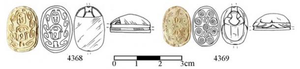 In the tomb labeled A2, archaeologists found two Egyptian-like amulets, known as scarabs.