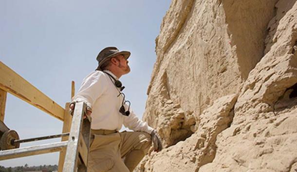 From the top of a tall scaffold, Yale Egyptologist John Darnell examines large hieroglyphs discovered along an ancient trade route. (Yale photo)