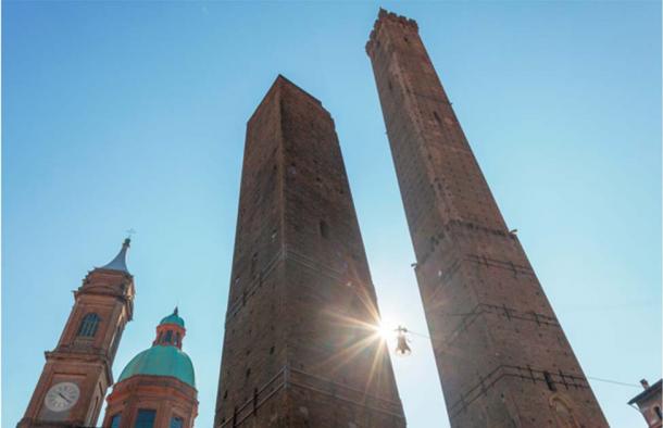 The towers bear the names of the influential families who constructed them. The two leaning structures stand as the iconic symbols of Bologna. (Guido/Adobe Stock)