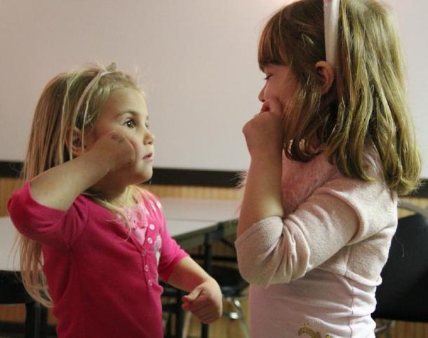 Two girls communicating via unspoken language. (Mr. Stradivarius / CC BY-SA 2.0)