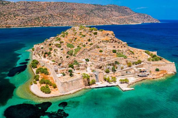 Aerial view of Spinalonga on the Greek island of Crete. Source: whitcomberd / Adobe Stock. Spinalonga was fortified from its earliest years to protect the entranceway of the port of ancient Olous. Olous was depopulated in the 7th century because of the raids of the Arab pirates in the Mediterranean. During Venetian rule, in the 15th century, salt was harvested from salt pans around the island. The island was subsequently used as a leper colony from 1903 to 1957. The last inhabitant, a priest, left the island in 1962.