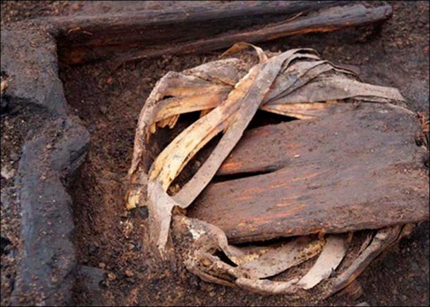 Leather wallet. Clay pot wrapped in birch bark.