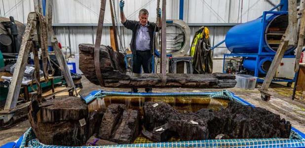 The “Tetney Golf Club” Bronze Age coffin, made from a massive split oak tree, being carefully lifted to a restoration workstation.
