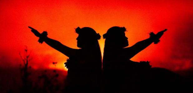 Hawaiian girls dancing in front of volcano (Julia Held/ Adobe Stock)
