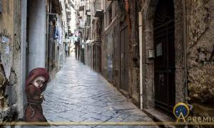 Scenic view of typical narrow alleyway lined laundry lines in the Medieval Centro Storico of Naples ( lazyllama/ Adobe Stock) and Munaciello according to popular imagery ( Lady of a times /CC BY-SA 4.0)
