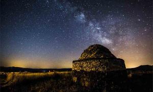 A view of a reconstructed hut at the Nuraghe Antine site at night.