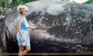 Phallic megalith covered with glyphs and author in the Pohnpaid meadow (Image © 1992 Carole Nervig)