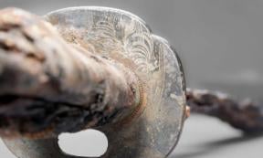 Detailed view of the Japanese swords guard plate (tsuba) with the inlaid and melted chrysanthemum motif and the water lines.