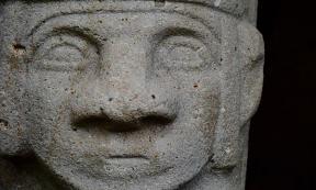 An ancient carved stone face of a megalithic statue in the San Agustín Archaeological Park, Colombia. 