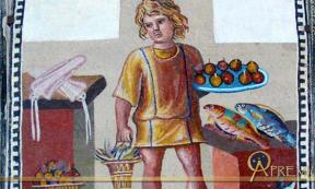 A boy holding a platter of fruits with a bucket of crabs, in a kitchen with fish and squid, on the June panel from a mosaic depicting the months (3rd century)