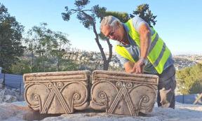 Director of the Jerusalem Promenade excavation Yaakov Billig with the unearthed capitals that likely were part of a First Temple Period palace.            Source: Yoli Shwartz / Israel Antiquities Authority
