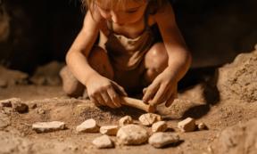 Representative image of Neanderthal child playing with a collection of stones.