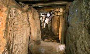 Western passage at the megalithic site of Knowth with decorated orthostat on left. Co. Meath, Ireland.