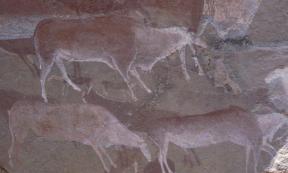 Prehistoric rock art using ochre paint on a cave wall in Drakensberg, South Africa
