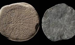 Two sun stones found on the Danish island of Bornholm in the Baltic Sea. The prehistoric artifacts are small, flat, shale pieces with finely incised patterns and sun motifs.
