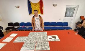 Roman metal detectorist Marius Mangeac stands in front of the Roman coins he discovered near the village of Letţa Veche.