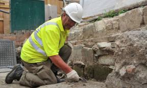 Cotswold Archaeology worker excavating in the area where the medieval graves and other artifacts were discovered. 