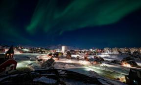 Nuuk, Greenland skyline with the aurora borealis shining overhead.