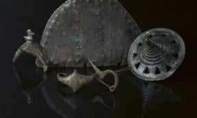 Early Iron Age metal finds from Somló Hill, including a sculpted disc, a brooch, and a large pendant.