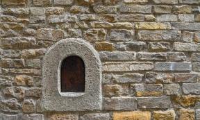 A wine window (buchetta del vino), used in the past to sell wine directly to passers-by, on the old stone wall of an ancient building in the historic centre of Florence, Tuscany, Italy. Source: Simona Sirio /Adobe Stock