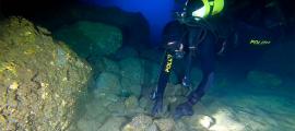 A diver from the underwater unit of the Naples Police examines a piece of obsidian on the seafloor near the island of Capri, Italy.	Source: Naples Superintendency for Archaeology, Fine Arts and Landscape