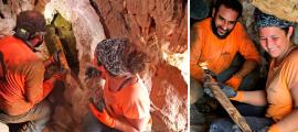 Archaeologists Oriya Amichay and Hagay Hamer removing one of the Roman swords from the crevice where they were hidden. Source: Amir Ganor/Israel Antiquities Authority