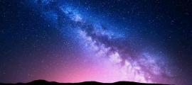 Milky Way and pink light over mountains. Source: den-belitsky/Adobe Stock