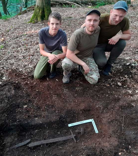 The three local historians standing above the 1000-year-old Boleslaw sword they found and turned in to the authorities. (Joanna Klimek-Szymanowicz Wójt Gminy Lewin Kłodzki / Polish Press Agency) 